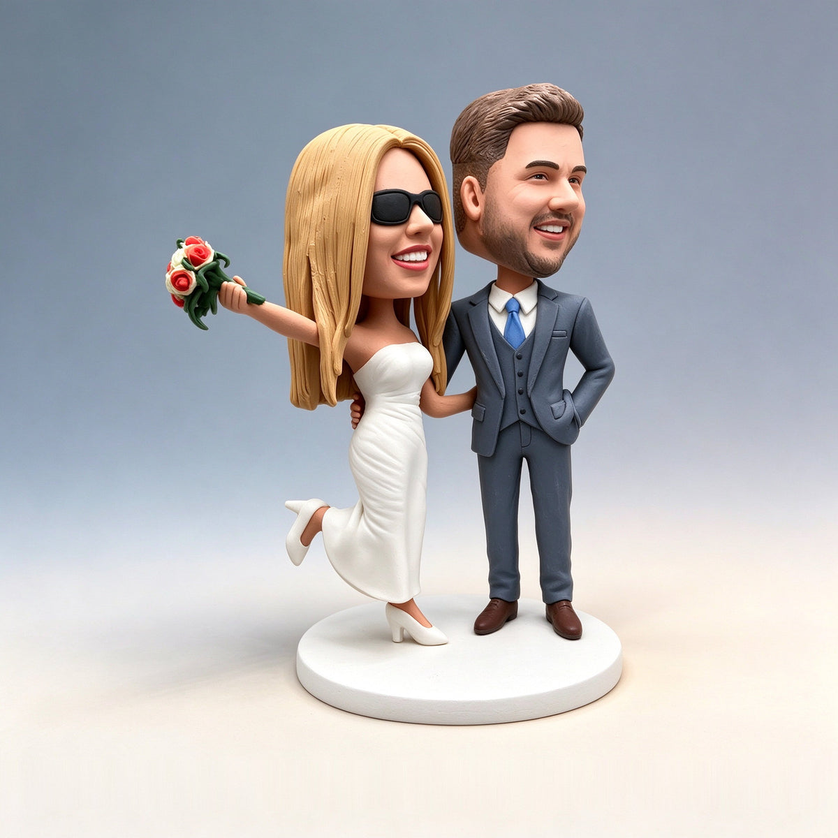 Handmade polymer clay wedding couple figurine: bride in sunglasses and white dress holding a bouquet, groom in a blue suit